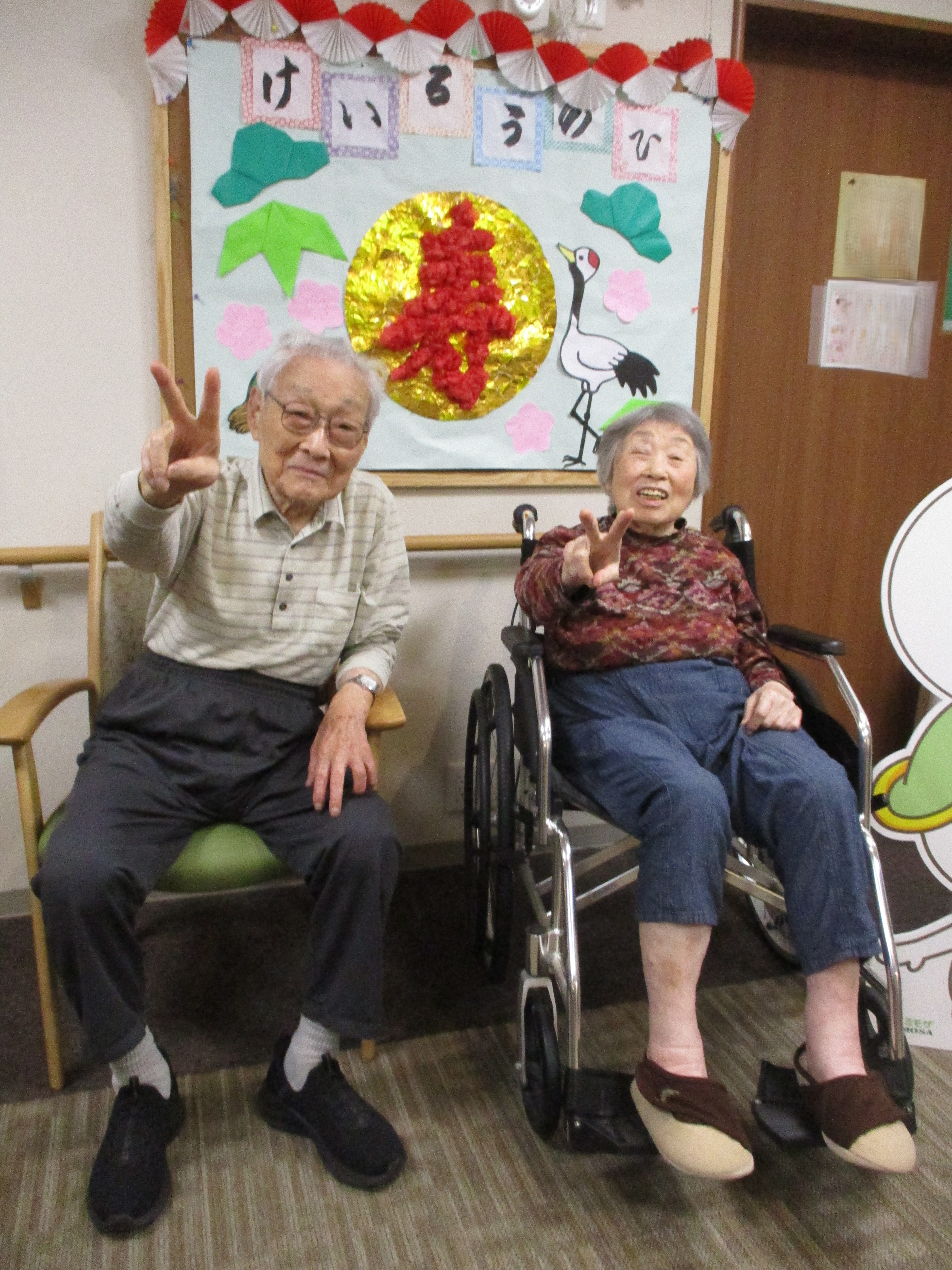 敬老のお祝いの壁画の前で写真